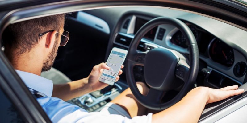 ease2pay-bg Young handsome man driving luxury car. Man is using ridesharing service app to provide driving service to new customers
