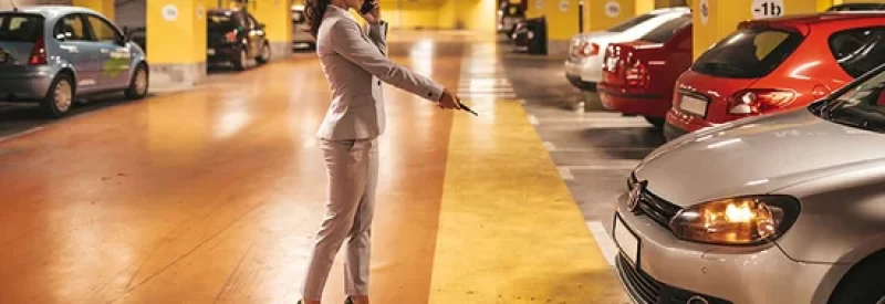 elegante-zakenvrouw-die-haar-auto-vergrendelt-met-sleutels-in-een-ondergrondse-parkeergarage 550px